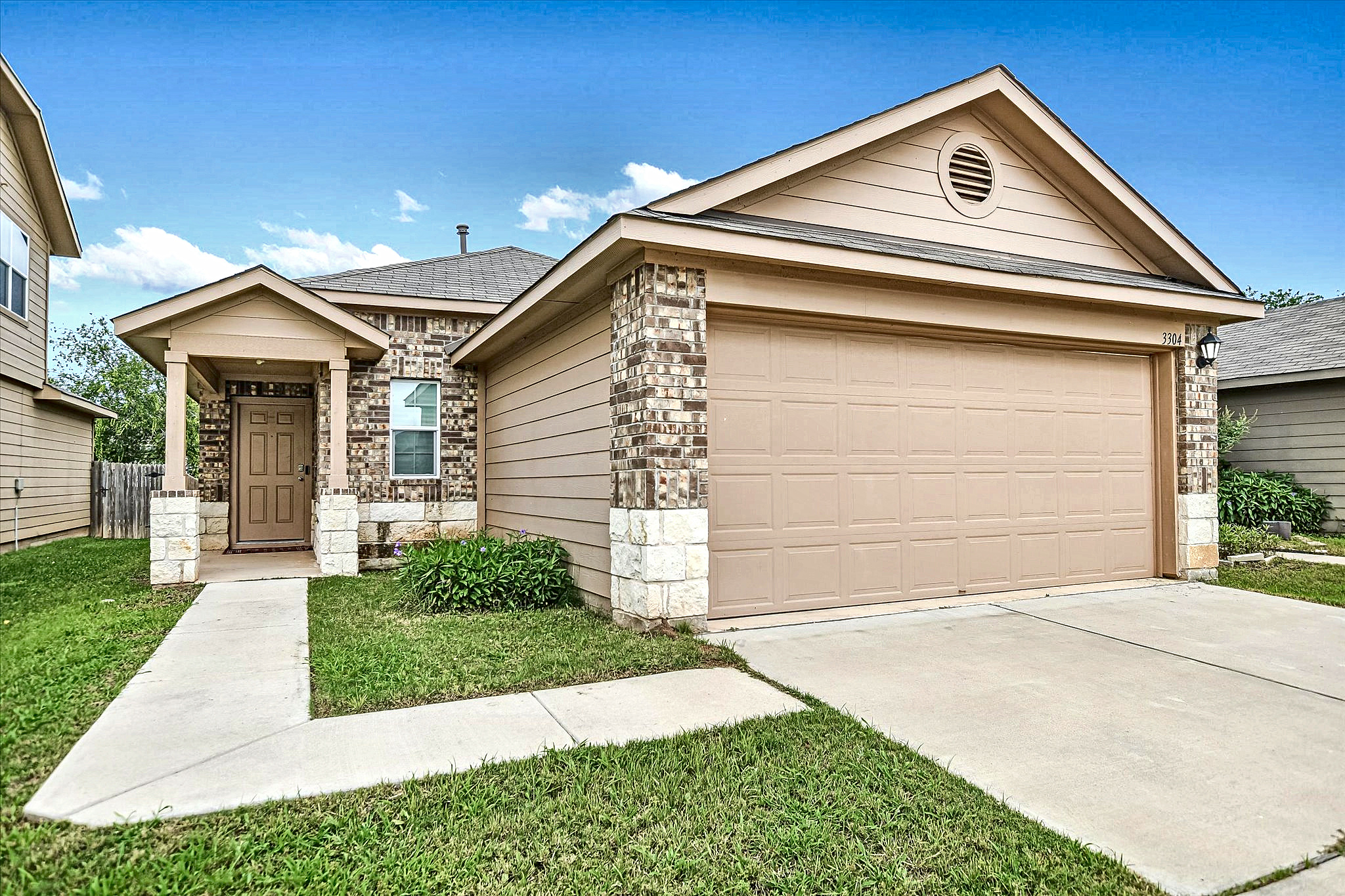 3304 Tilmon Ln. Austin, TX 78725 - Photo 1 of 1 A welcoming facade with a covered entry and attached garage, offering both shelter and convenience.