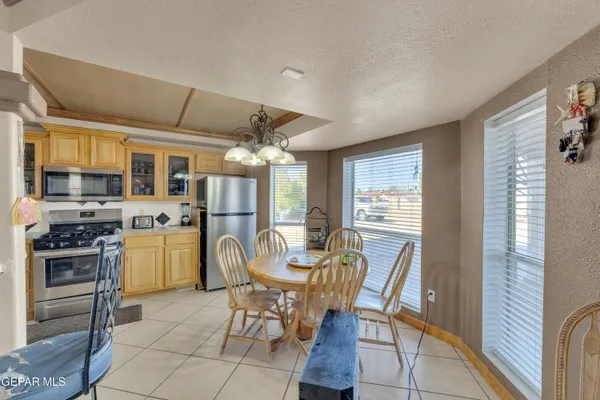a kitchen with refrigerator and chairs