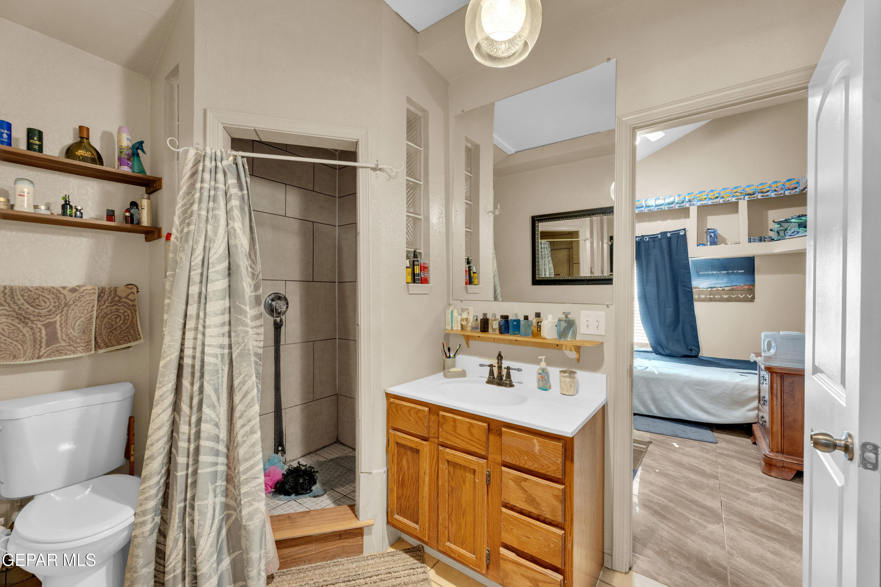 16020 Harrison Road El Paso, TX 79928 - Photo 31 of 56 a bathroom with a toilet sink a mirror a bathtub and shower