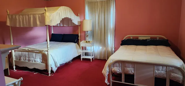 a bedroom with a bed a mirror and dresser