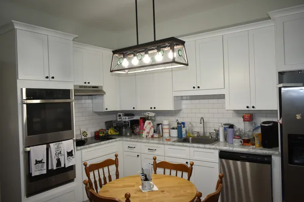 a kitchen with stainless steel appliances granite countertop a stove a refrigerator a microwave a sink and cabinets