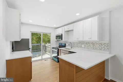 a kitchen that has a sink a table and chairs in it