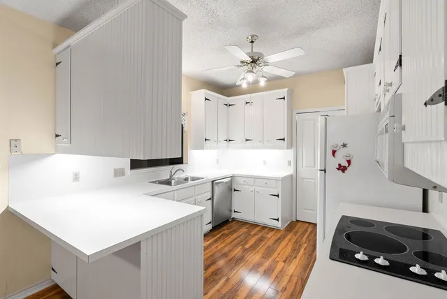 a kitchen with a sink dishwasher and white cabinets