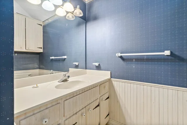 a bathroom with a sink a mirror and a light fixture