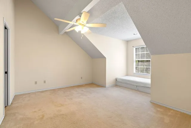 an empty room with a window and a ceiling fan