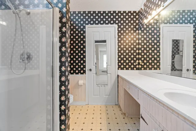 a bathroom with a sink a toilet and shower