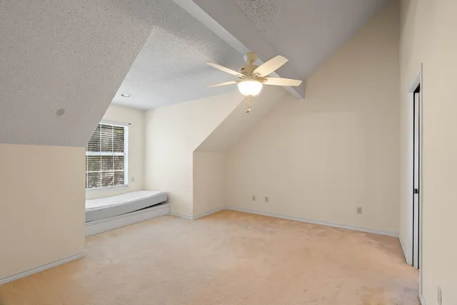 an empty room with a ceiling fan and window