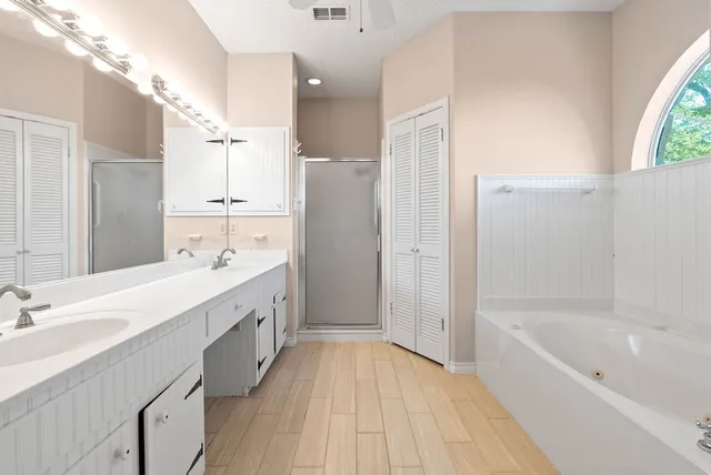 a spacious bathroom with a double vanity sink a mirror and a bathtub