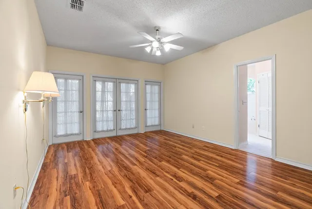 a view of a livingroom with wooden floor and a ceiling fan