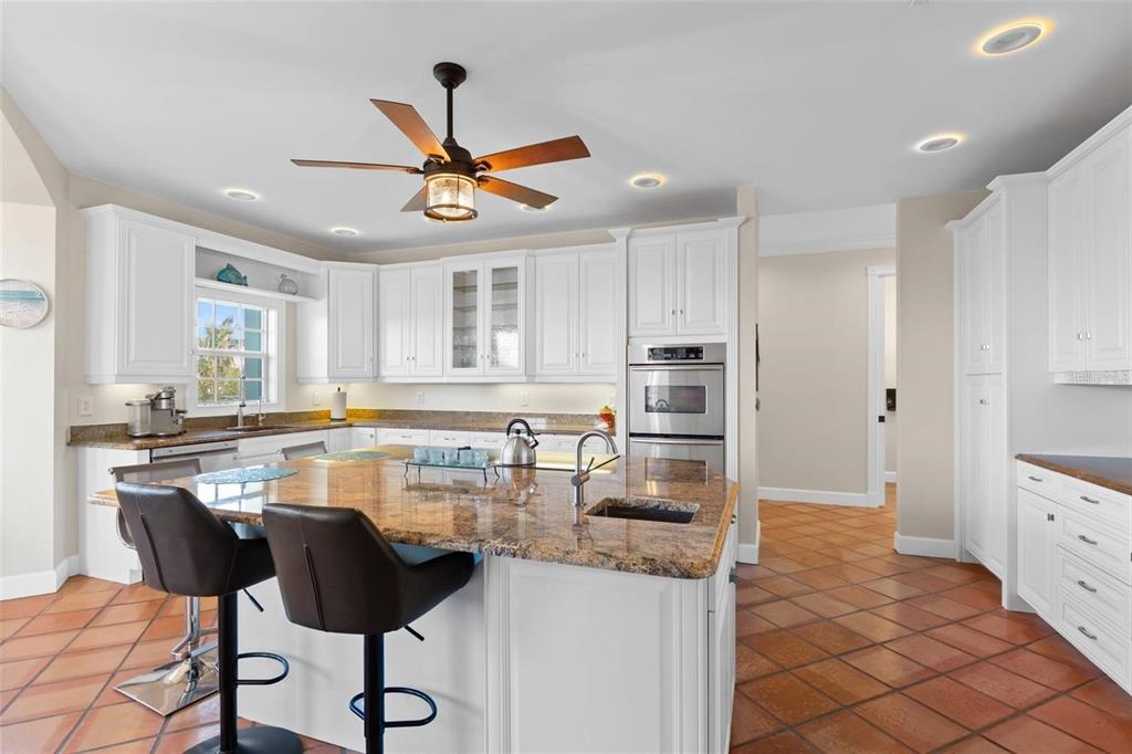63 Palm Drive Placida, FL 33946 - Photo 14 of 54 a kitchen with stainless steel appliances kitchen island granite countertop a table chairs and a refrigerator