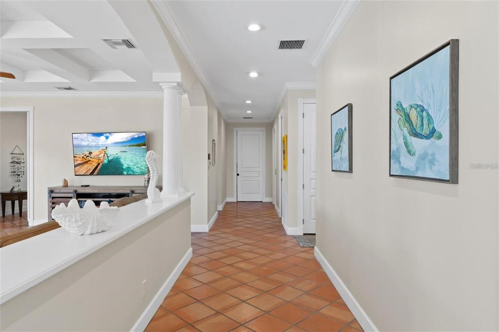 63 Palm Drive Placida, FL 33946 - Photo 18 of 54 a view of a hallway with a dining table and paintings on the wall
