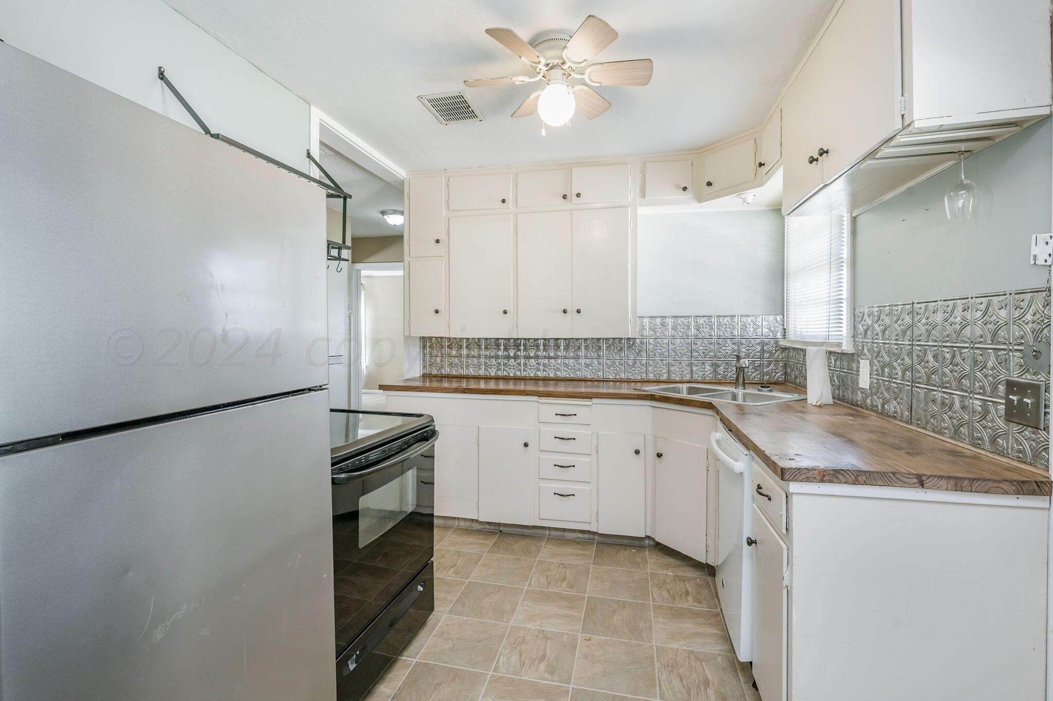 4108 South Travis Street Amarillo, TX 79110 - Photo 5 of 15 a kitchen with granite countertop cabinets and refrigerator
