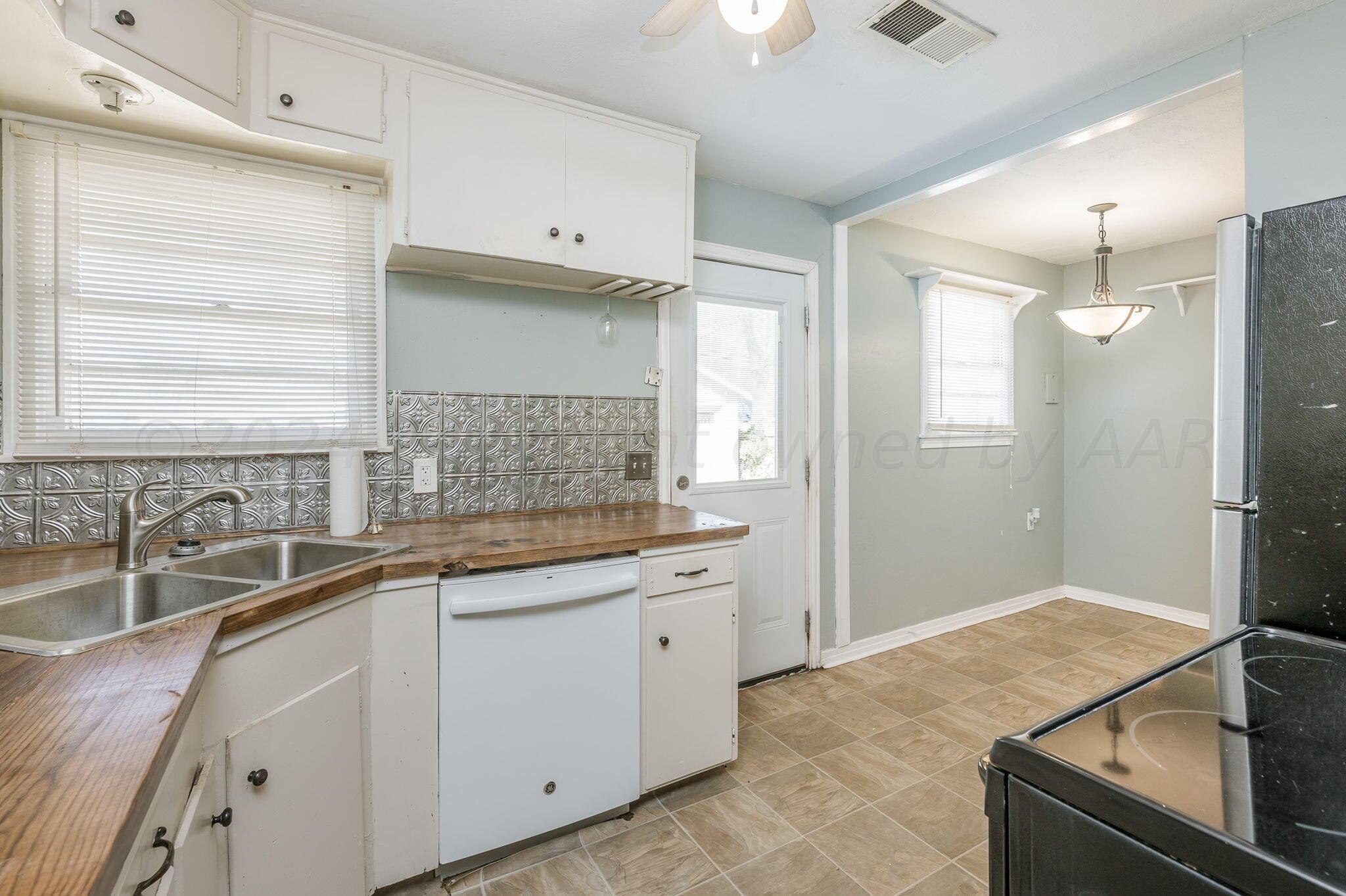 4108 South Travis Street Amarillo, TX 79110 - Photo 7 of 15 a kitchen with a sink and refrigerator