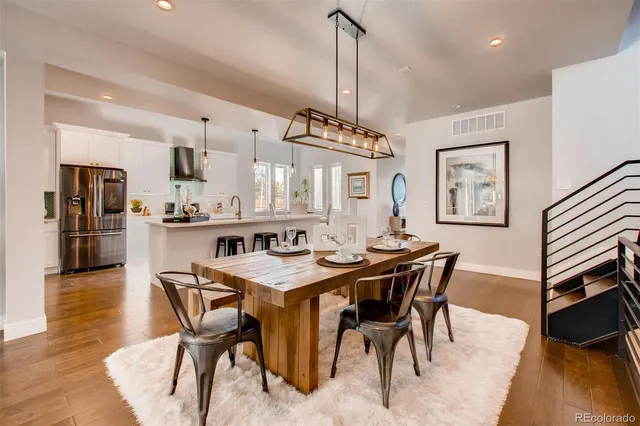 a dining room with stainless steel appliances kitchen island a table and chairs