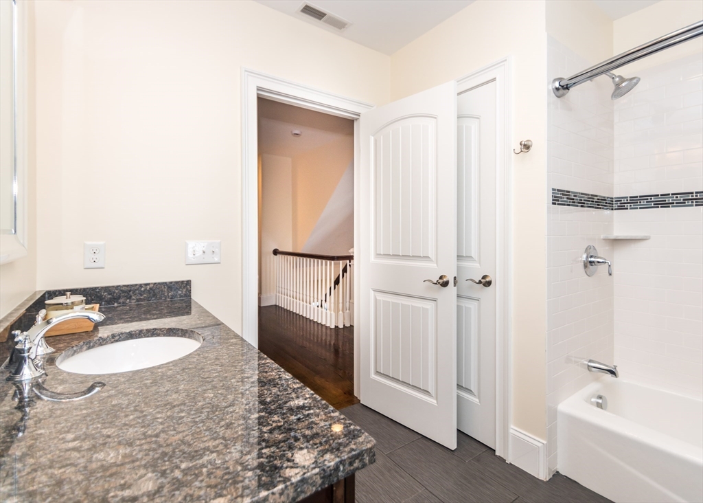 128 Church Street, Unit 2 Waltham, MA 02452 - Photo 21 of 41 a bathroom with a granite countertop sink and a mirror