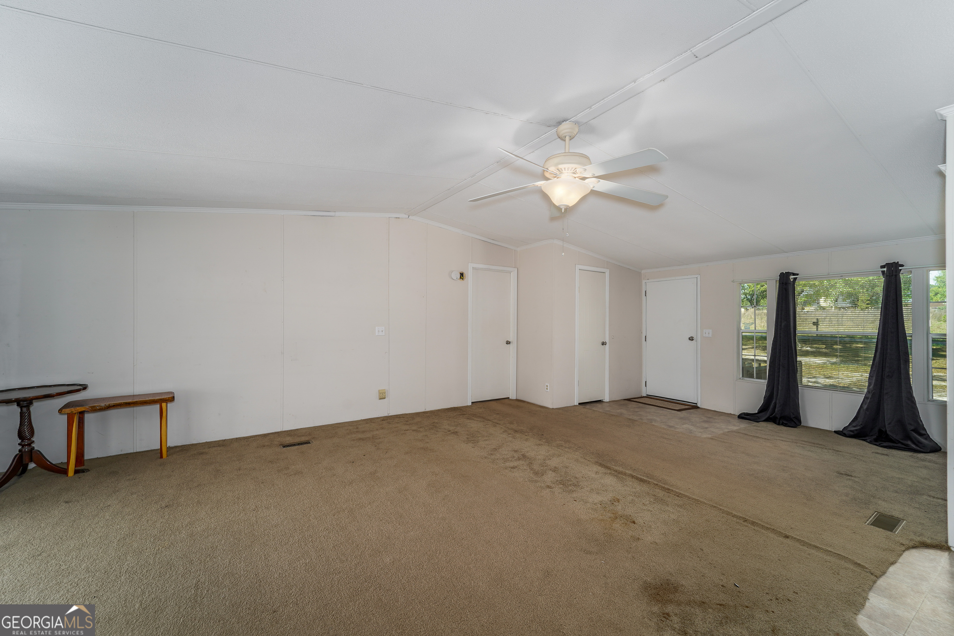 3642 Tanner Lane Waycross, GA 31503 - Photo 23 of 36 an empty room with chandelier fan and windows