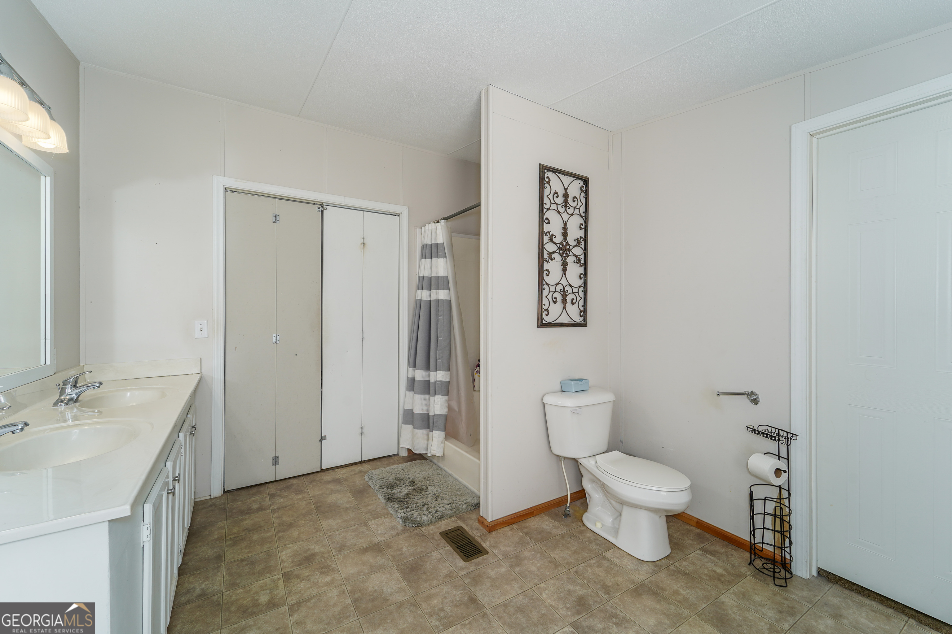 3642 Tanner Lane Waycross, GA 31503 - Photo 32 of 36 a spacious bathroom with a toilet sink and a mirror