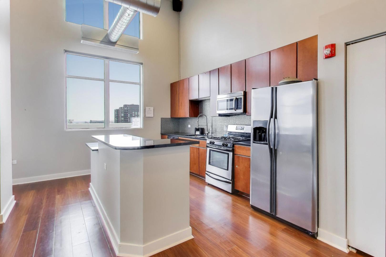 901 West Madison Street, Unit 710 Chicago, IL 60607 - Photo 24 of 35 a kitchen with stainless steel appliances granite countertop a refrigerator a sink dishwasher a stove and white countertops with wooden floor