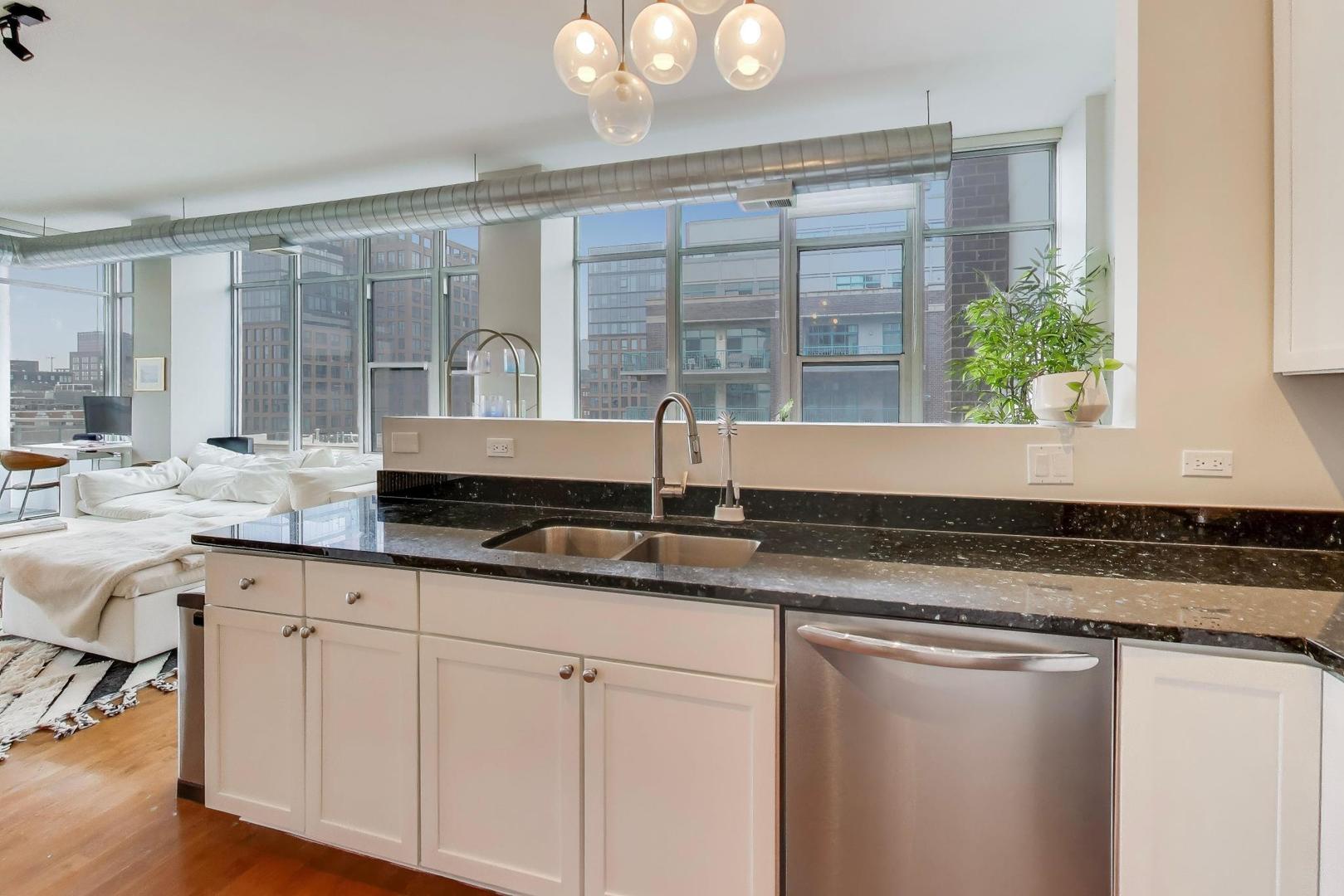 901 West Madison Street, Unit 710 Chicago, IL 60607 - Photo 6 of 35 a kitchen with granite countertop a sink and white cabinets