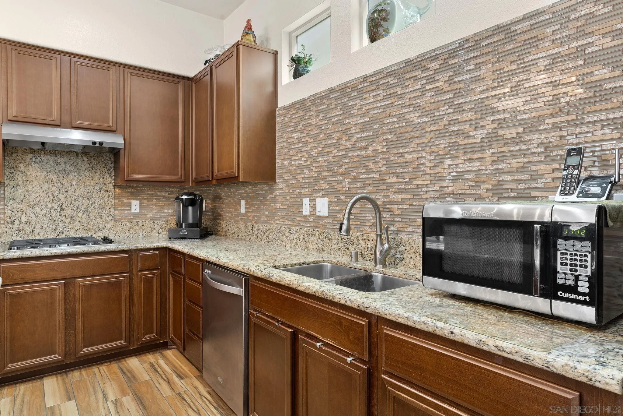 1438 Pershing Road Chula Vista, CA 91913 - Photo 8 of 45 a kitchen with stainless steel appliances wooden cabinets a sink and a stove