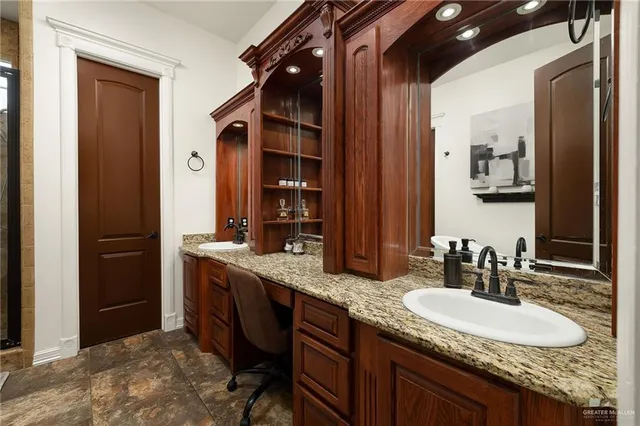 a bathroom with a granite countertop sink and a mirror