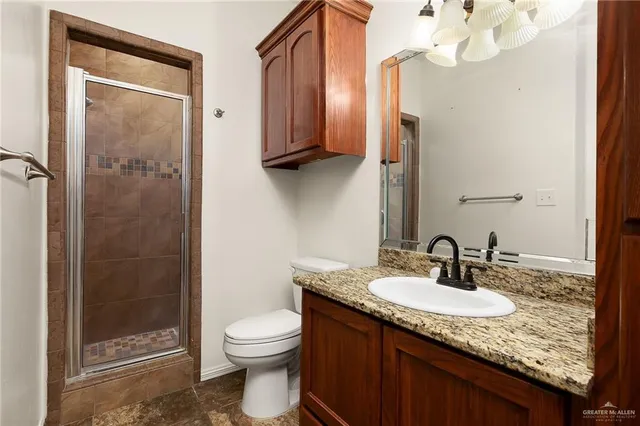 a bathroom with a granite countertop sink toilet and shower