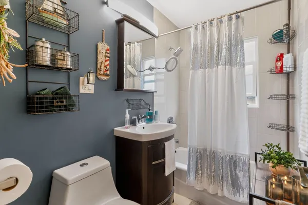 a bathroom with a sink a toilet and shower curtain