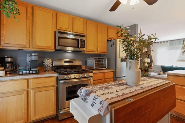 a kitchen with stainless steel appliances granite countertop a stove a sink dishwasher and microwave oven with cabinets