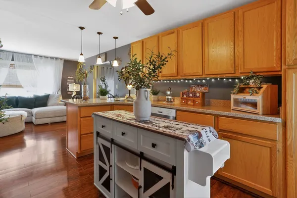 a living room with stainless steel appliances kitchen island granite countertop furniture and a large window