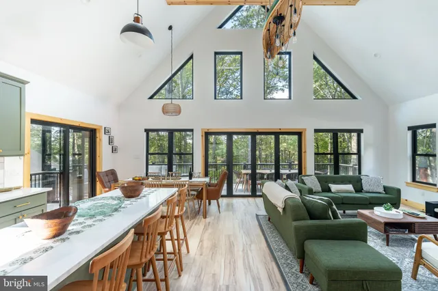 a dining room with furniture a chandelier and wooden floor