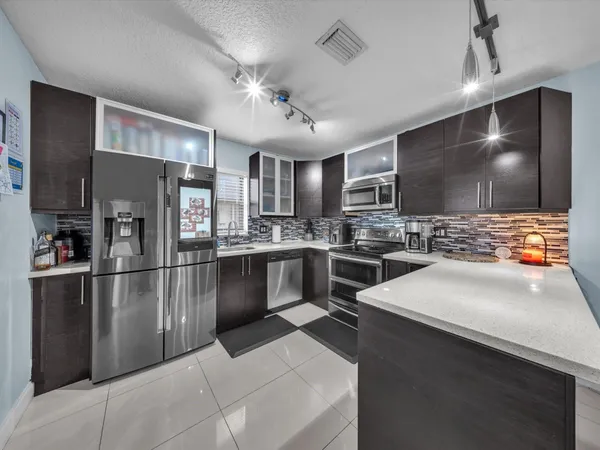 a kitchen with stainless steel appliances a refrigerator sink and microwave