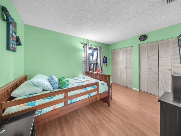 a bedroom with bed and wooden floor