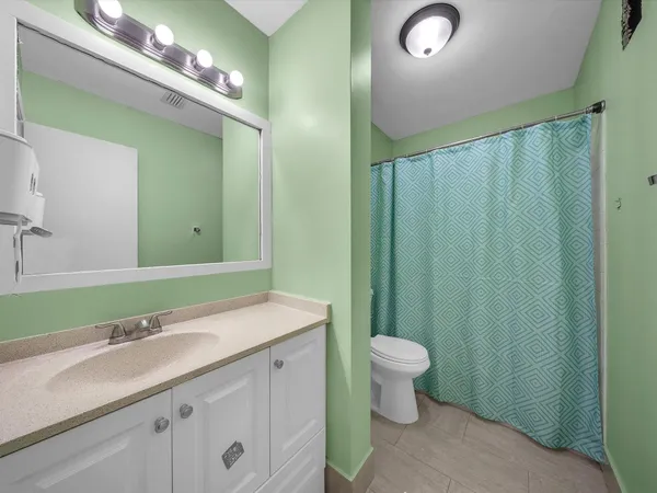 a bathroom with a sink a toilet a mirror and vanity