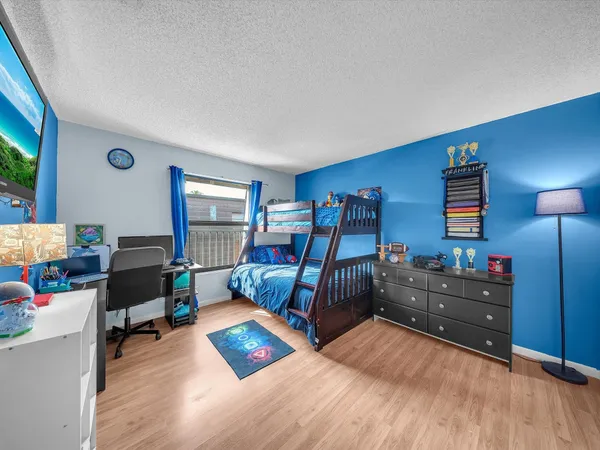 a bedroom with furniture and a wooden floor