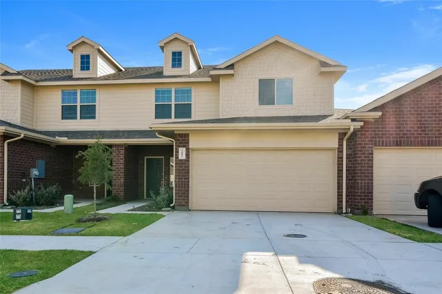 a view of a white house with a small yard and a large tree