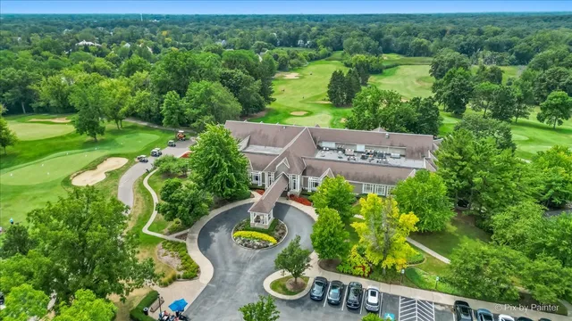 an aerial view of residential houses with outdoor space and trees