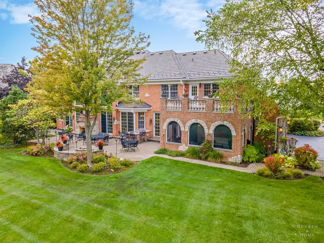 a front view of a house with garden and trees