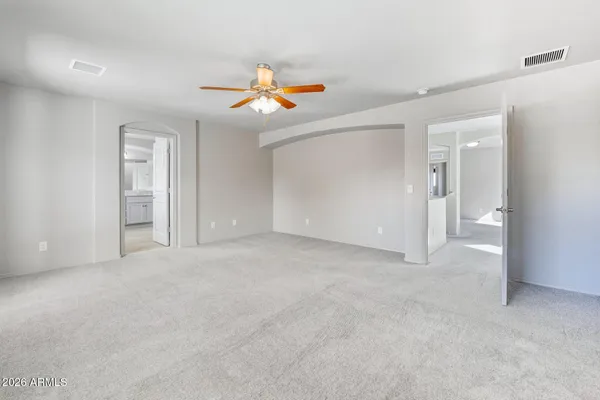 an empty room with windows and fan