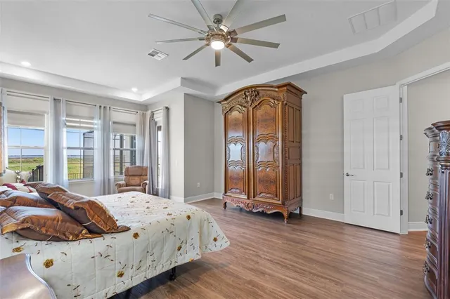 a bedroom with a bed next to a window and a chandelier