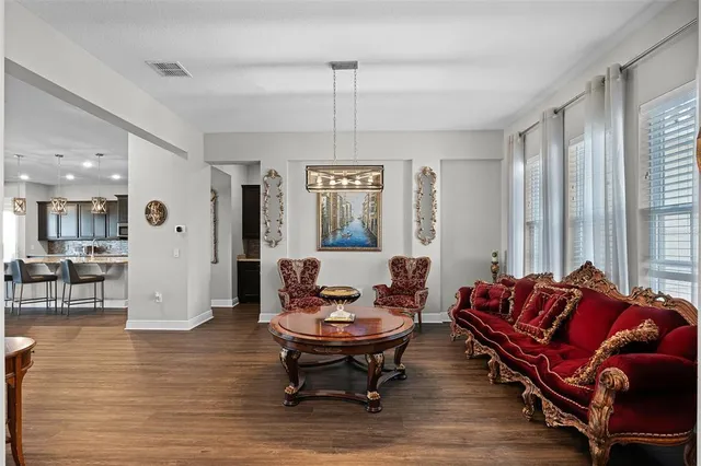 a living room with furniture a flat screen tv and kitchen view