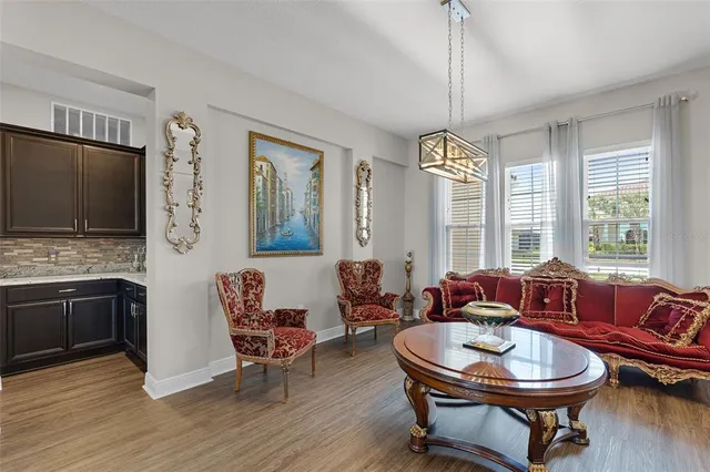 a view of a a dining room with furniture window and wooden floor