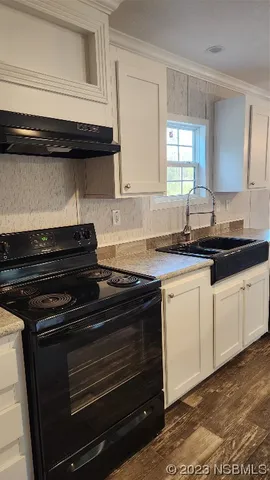a view of a kitchen with a sink and refrigerator
