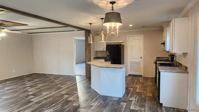 a view of a yard with plants and large trees