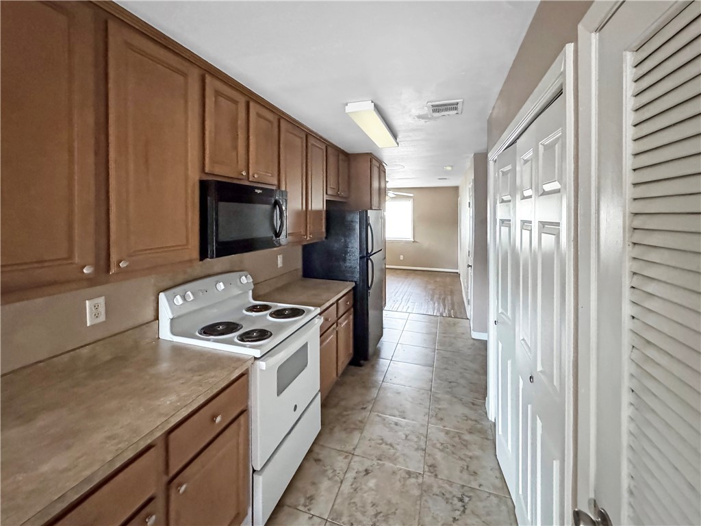 1601 South College Avenue, Unit 5 Bryan, TX 77801 - Photo 2 of 6 a kitchen with a stove a sink and a refrigerator