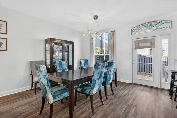 a kitchen with stainless steel appliances granite countertop a refrigerator a stove a sink and a dining table with wooden floor