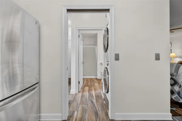 a view of a hallway with wooden floor and a bathroom