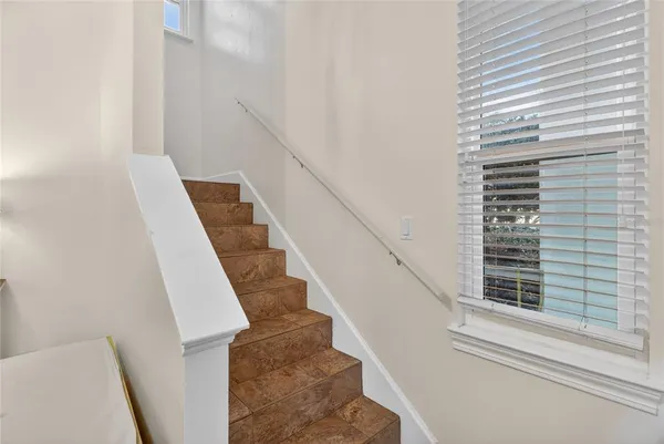 a bedroom with a bed a desk and chair with wooden floor