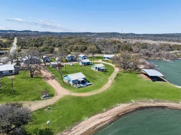 an aerial view of a house with a yard and lake view
