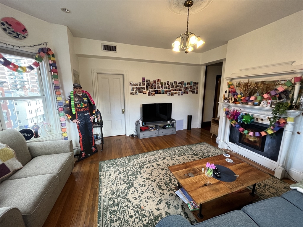142 St Alphonsus Street, Unit 3 Boston, MA 02120 - Photo 3 of 13 a bed room with furniture and a flat screen tv