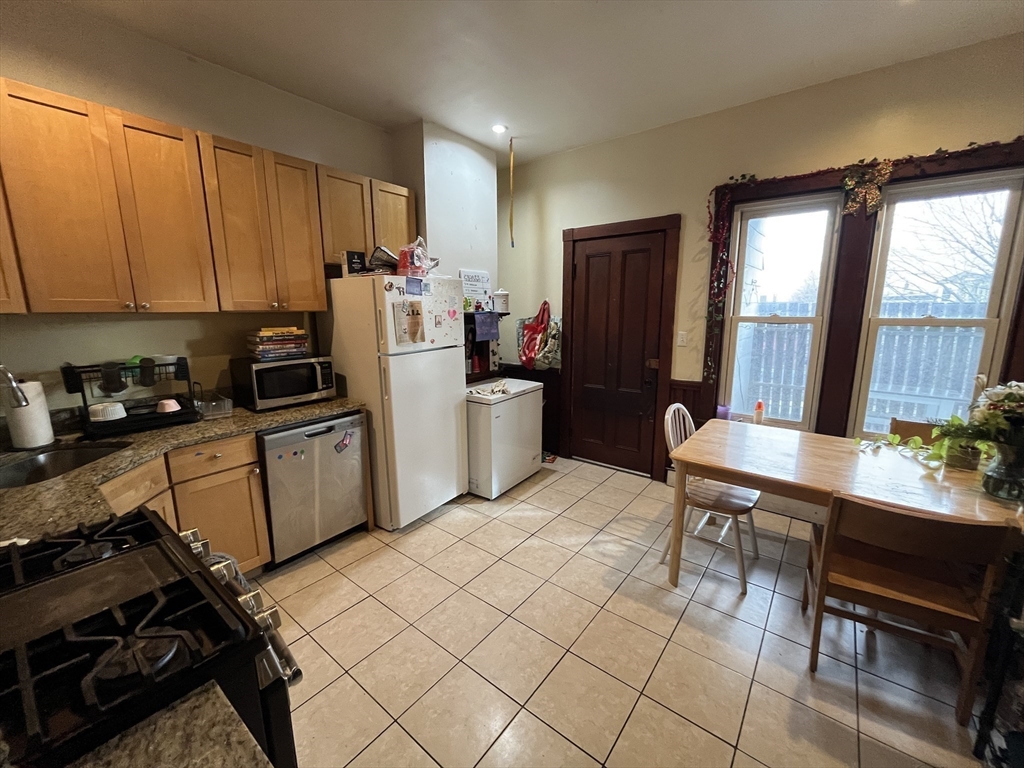 142 St Alphonsus Street, Unit 3 Boston, MA 02120 - Photo 6 of 13 a kitchen with a refrigerator a stove a sink dishwasher and cabinets with wooden floor